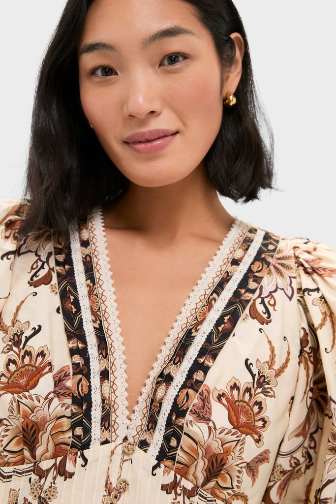 Young woman models the Majestic Garden Sand Blouse, a classic, high-end bohemian top with warm-toned florals, featuring effortless lace trim and pintuck details.