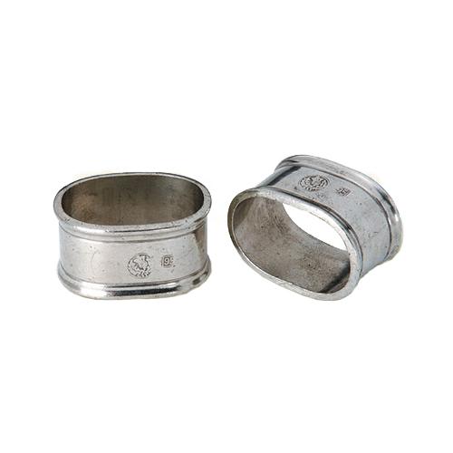 The MATCH Oval Napkin Ring Set of Two by MATCH features oval-shaped handmade pewter napkin rings with engraved markings, displayed lying on their sides against a white background.