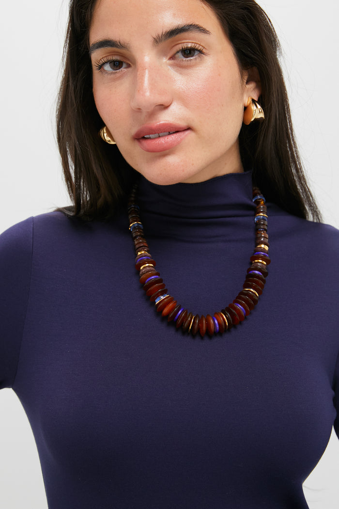 Woman wearing the Multi Amaranth Necklace, a classic, high-end piece with warm-toned, disk-shaped beads. Effortlessly fun and perfect for any occasion.