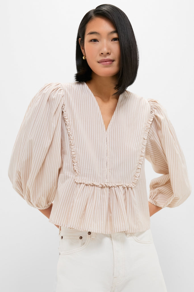 Natural Stripe Stevie Blouse: A classic, effortless blouse with vertical pinstripes, ruffle trim, and balloon sleeves, paired with high-waisted jeans for a high-end, fun look.