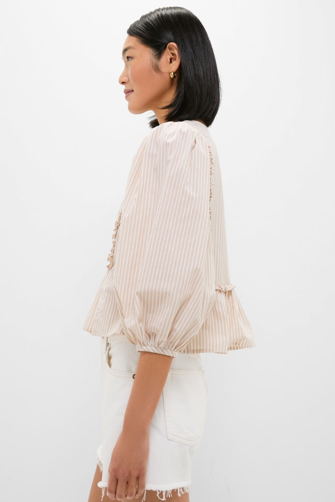 Young woman models the Natural Stripe Stevie Blouse, featuring a classic, effortless design with three-quarter puff sleeves and peplum hem, paired with high-waisted white shorts.