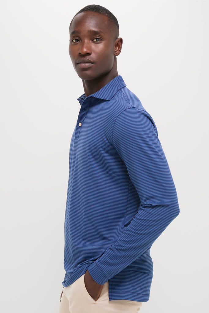 Young man in a classic, high-end Navy Lyons Performance Jersey Long Sleeve Polo, embodying effortless style and fun with a three-button placket and fine stripes.