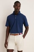 Young man models the Navy Ryles Crown Flex Cotton Polo, showcasing its classic cutaway collar and effortless, high-end style, paired with beige chino shorts and a striped belt.