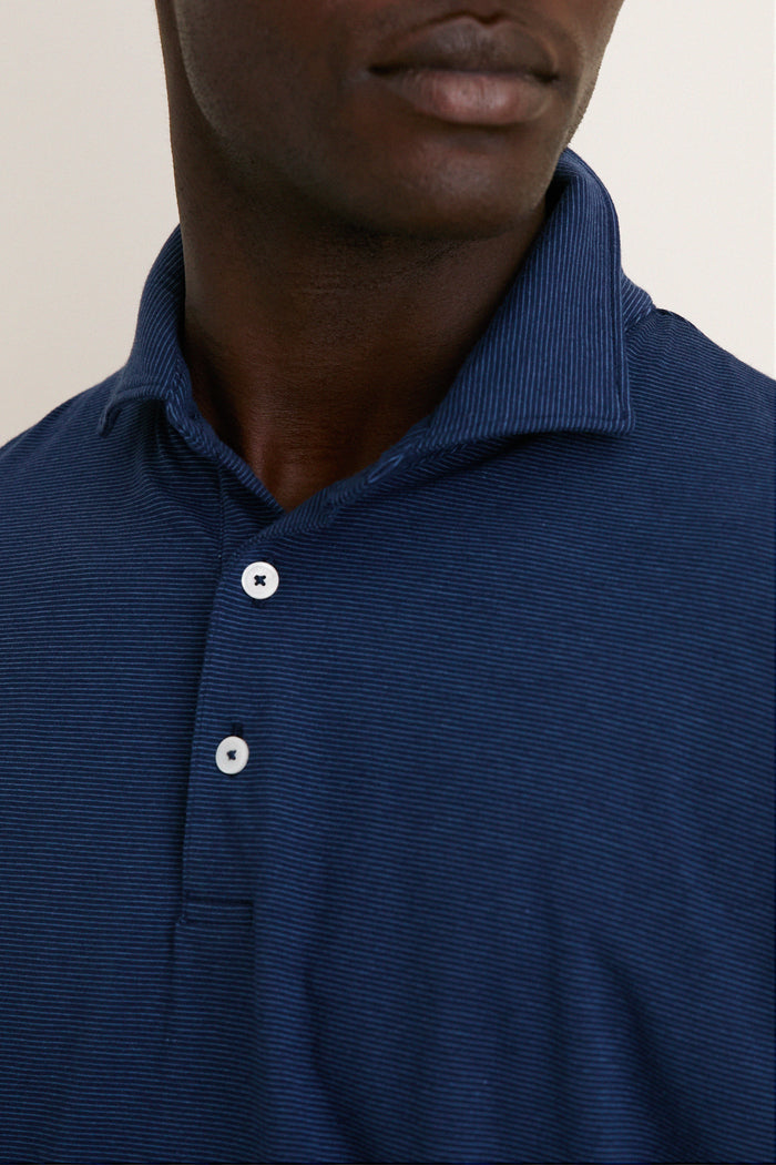 Close-up of a person wearing the Navy Ryles Crown Flex Cotton Polo, showcasing its classic cutaway collar and partial button placket for an effortless, high-end look.