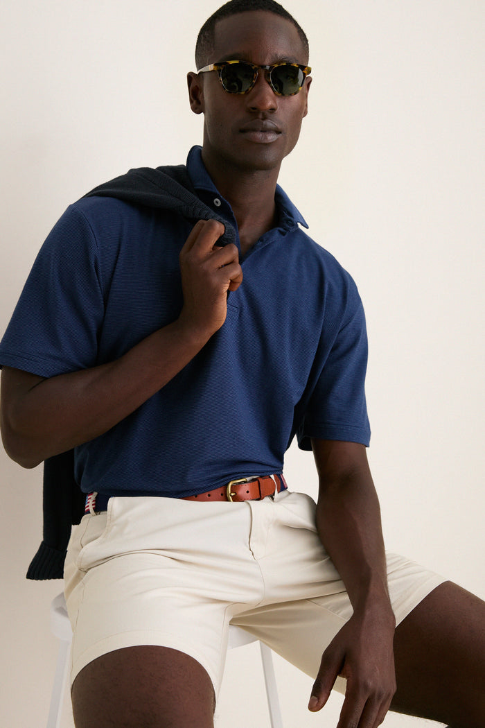 Man models Navy Ryles Crown Flex Cotton Polo, embodying effortless, high-end style with classic features like a cutaway collar and shorter sleeves, perfect for fun, casual wear.