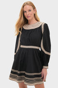 Model wearing the Noir Fiora Mini Dress, a classic, high-end black dress with playful zig-zag trim, effortlessly blending fun and sophistication with its voluminous silhouette.