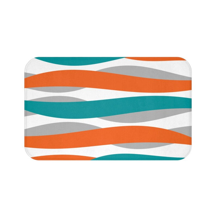 abstract wave pattern in orange, teal, and light gray against a white background on a memory foam mat