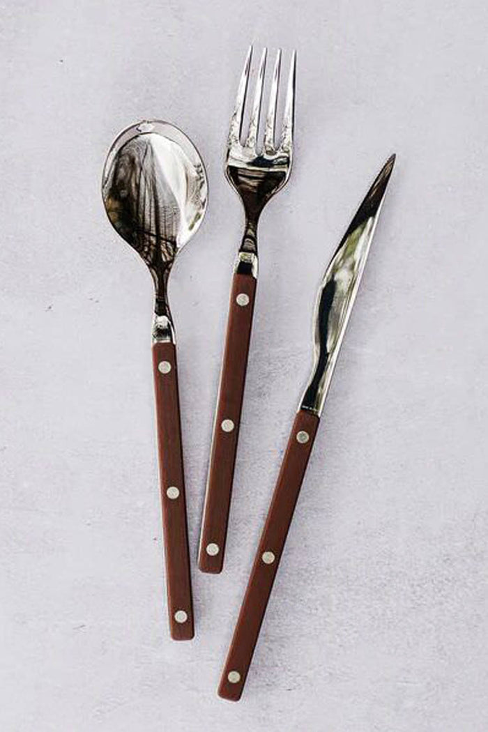 Pastello Brown Three-Piece Place Setting featuring a spoon, fork, and knife with durable stainless steel heads and classic brown riveted handles, embodying effortless, fun, high-end dining style.