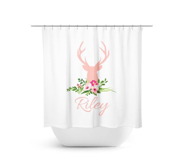 Image of a shower curtain with a pink deer head silhouette on top of a floral arrangement with green leaves and pink   flowers. A personalized name, in pink cursive-style letters is below the deer head.