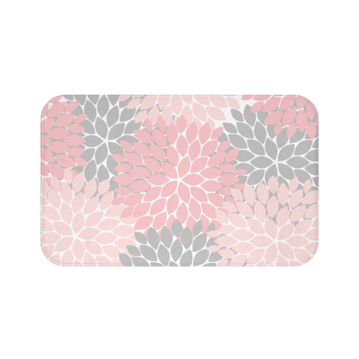 A rectangular memory foam mat with a muted color scheme consisting of a pink, soft pink (aka baby pink), and charcoal gray floral pattern, with anti-slip backing.