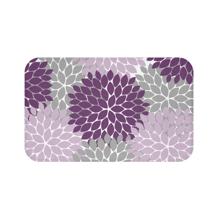 A rectangular memory foam mat with a muted color scheme consisting of a purple, light purple, and light gray floral pattern against a white background, with anti-slip backing.