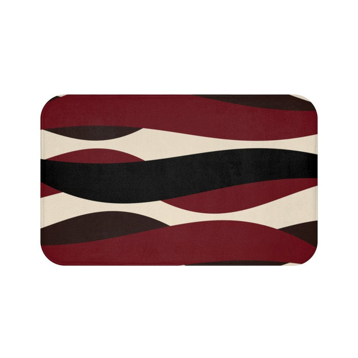 A rectangular memory foam mat with a geometric pattern featuring ribbons in red, black, and brown colors on a beige background.