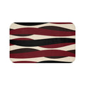 A rectangular memory foam mat with a geometric pattern featuring stripes in red, black, and brown colors on a beige background.