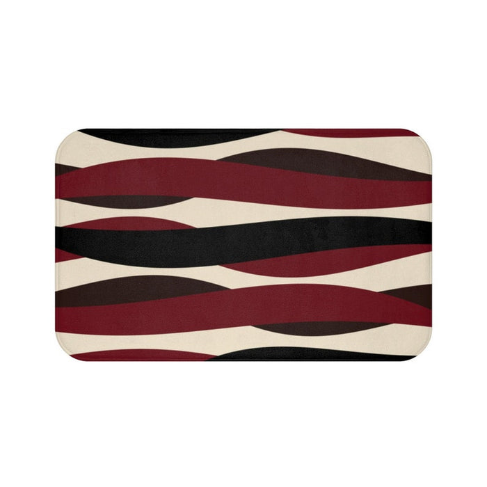 A rectangular memory foam mat with a geometric pattern featuring stripes in red, black, and brown colors on a beige background.
