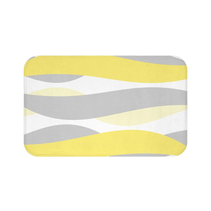 A rectangular yellow and gray abstract waves patterned memory foam mat with anti-slip backing.