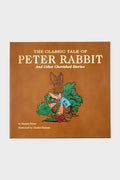Graphic Image’s brown book cover features The Classic Tale of Peter Rabbit and Other Cherished Stories, authored by Beatrix Potter with original illustrations by Charles Santore.