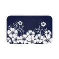 A rectangular memory foam mat with a printed blue and white hibiscus vine design and a solid, dark blue background.