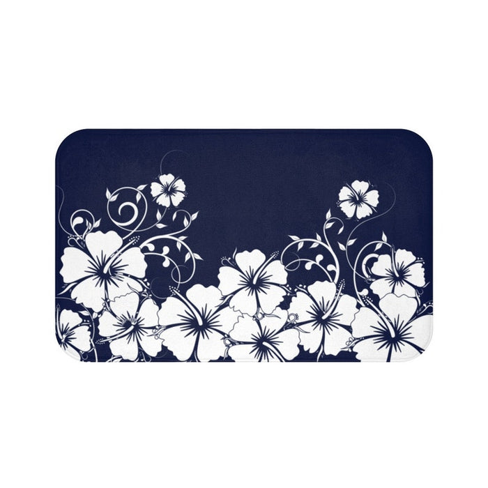 A rectangular memory foam mat with a printed blue and white hibiscus vine design and a solid, dark blue background.