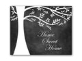 A black and white chalkboard art print featuring a hand-drawn, white tree silhouette and the phrase 'Home Sweet Home' written on it in a white, cursive script in the lower right hand area.