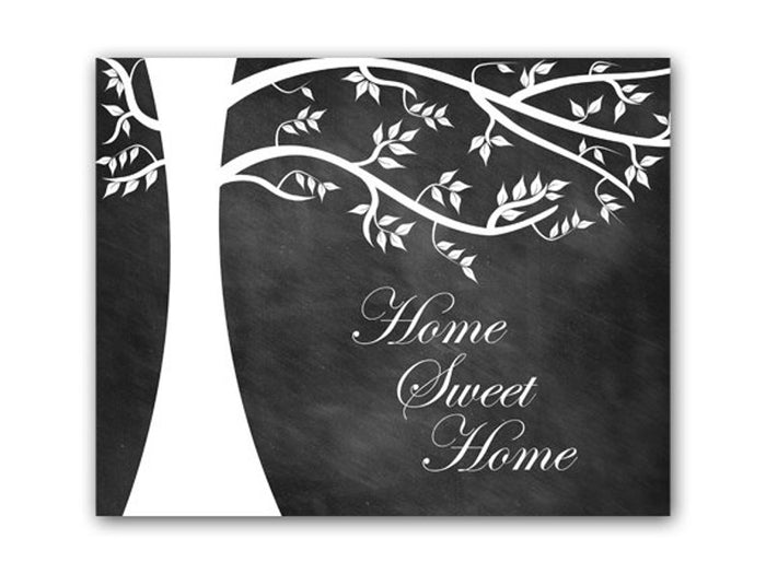 A black and white chalkboard art print featuring a hand-drawn, white tree silhouette and the phrase 'Home Sweet Home' written on it in a white, cursive script in the lower right hand area.